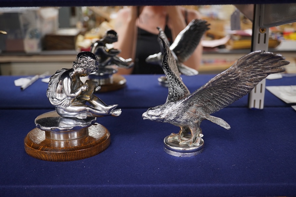 Two chrome car mascots, one in the form of an eagle stamped Finnigans London, wingspan 26cm, and the other of a classical child writing, mounted on a substantial radiator cap and oak base. Condition - fair to good, some